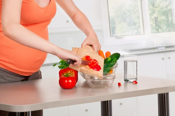 Zwangere vrouw koken in de keuken — Stockfoto