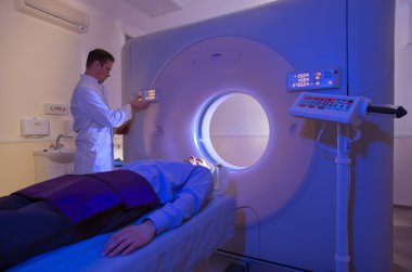 Technologist testing patient with CT Scan Machine clipart