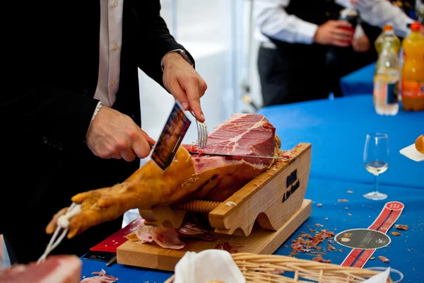 stock image Waiter is slicing ham