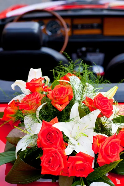 Bouquet di fiori su una macchina rossa — Foto Stock