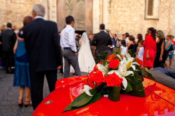 Bouquet de fleurs sur une voiture rouge — Photo