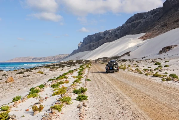 Hav, berg, vita sanddyner och bil — Stockfoto