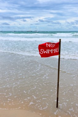 Red flag on the beach clipart