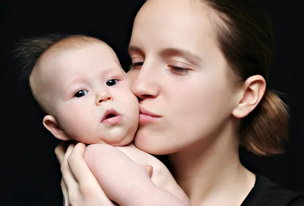 Anne küçük bebeğini öpüyor. — Stok fotoğraf