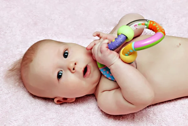 Newborn baby with colorfull rattle — Stock Photo, Image
