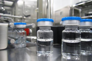 Bottles in the processing machine in a pharmaceutical plant clipart