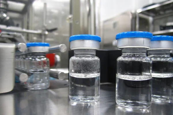 Butelki w maszynie przetwarzania w zakładzie farmaceutycznym — Zdjęcie stockowe