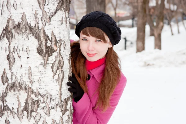 Mujer en un parque de invierno cerca de un abedul —  Fotos de Stock