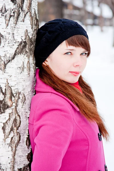 Frau im Winterpark in der Nähe einer Birke — Stockfoto