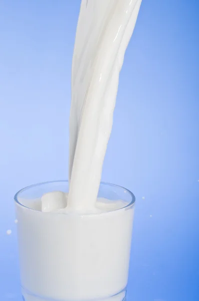 Наливая молоко в стакан — стоковое фото