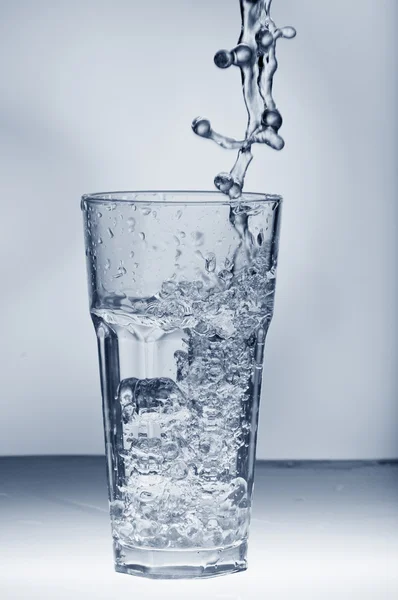 Frischwasser spritzt aus einem Glas mit Eis — Stockfoto