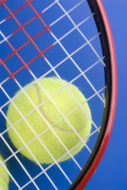 Tenis topu altında bir tenis raketi üzerinde mavi bir backgro bir parçası olduğunu