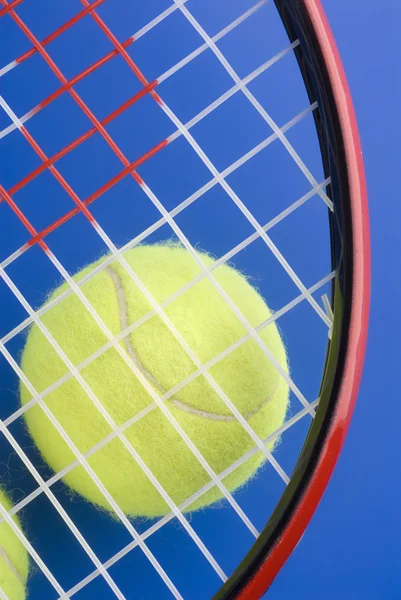 网球球是下一个网球拍上蓝色的 backgro 的一部分 — 图库照片