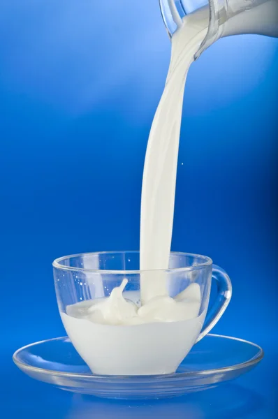 Milch in eine Tasse gießen — Stockfoto