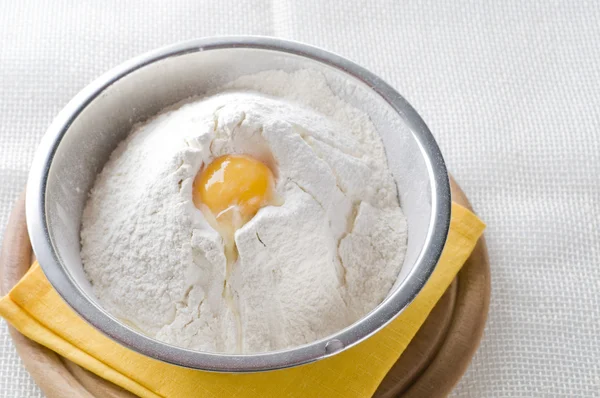 Белая мука и яйцо в миске — стоковое фото