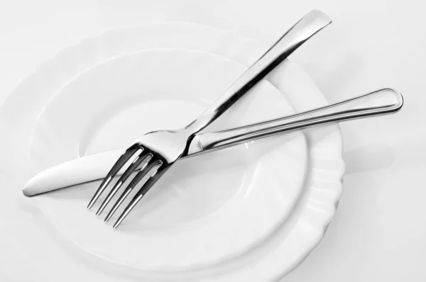 Kniv och gaffel på en tallrik — Stockfoto