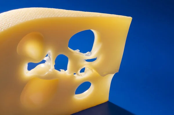 青色の背景にチーズ食品のクローズ アップ. — ストック写真