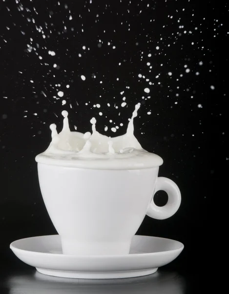 Milk splashing out of cup — Stock Photo, Image