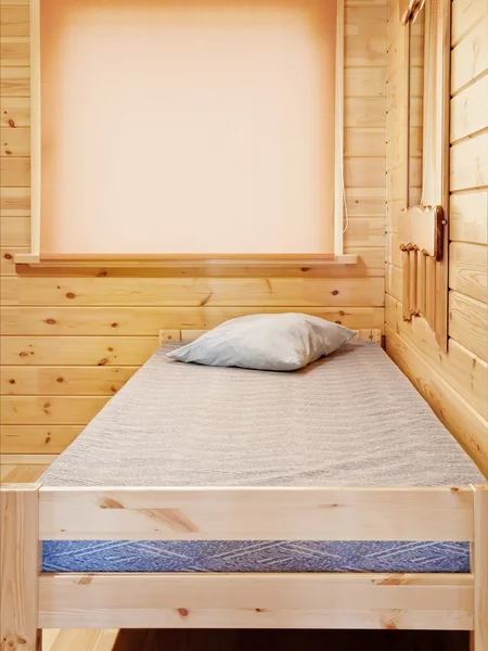 Кровать на деревянном фоне — стоковое фото