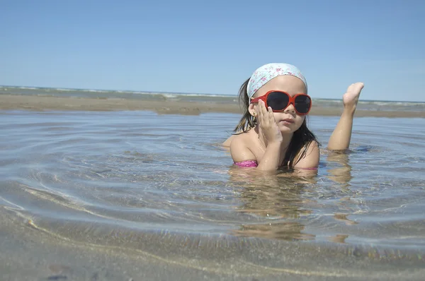 Schönes Mädchen liegt am Meeresufer — Stockfoto
