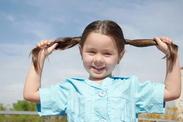 Meisje haar haren in handen houden — Stockfoto