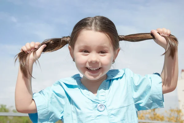 Joven chica sostener su cabello en las manos — Foto de Stock