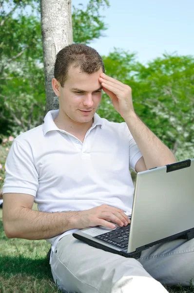 Working on laptop in a park — Stock Photo, Image