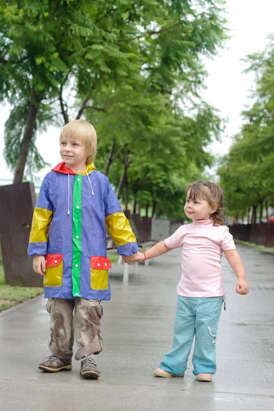 Garçon et petite fille sous la pluie — Photo