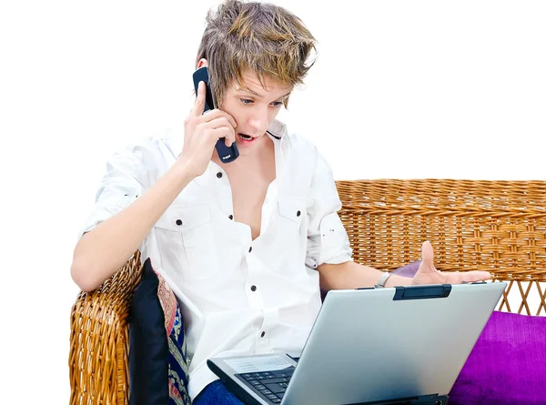 Hombre en el teléfono celular delante de la computadora portátil —  Fotos de Stock