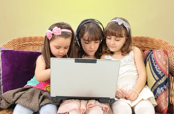 Three little girl in headphones with laptop — Stock Photo, Image