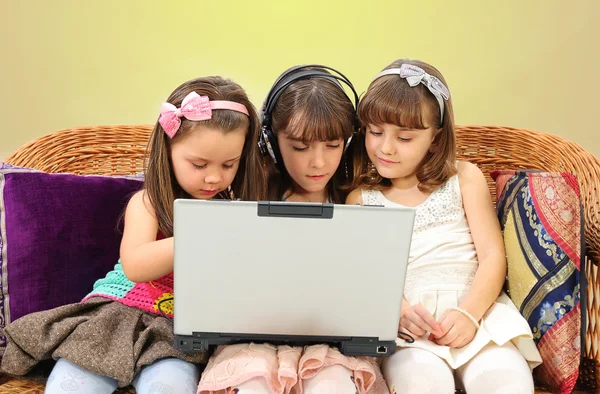 Tres niñita en auriculares con portátil —  Fotos de Stock