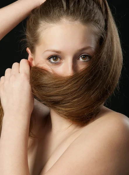 Дівчина закриває довге волосся в нижній частині людини. Аахма — стокове фото