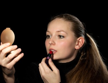 Kız bir ayna daha önce bir makyaj yapar