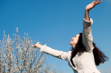 The happy attractive woman with the lifted hands clipart