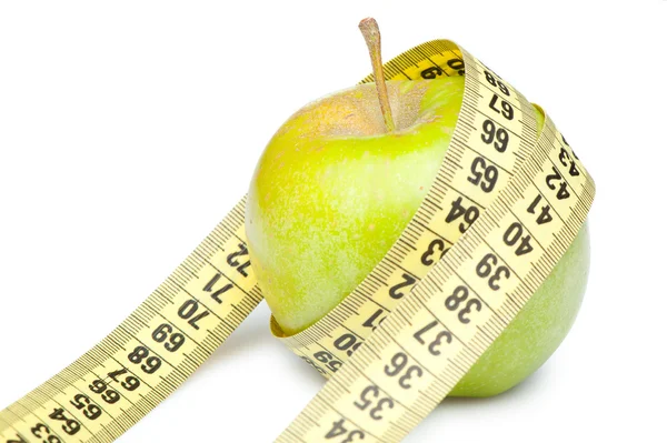 Bir ölçüm bandı ile yeşil elma closeup. Whit üzerinde izole — Stok fotoğraf