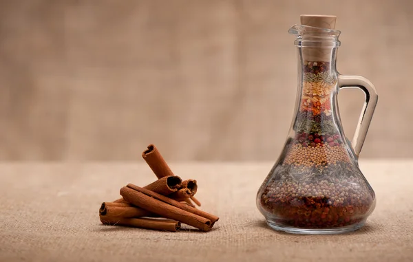 Bottle of spices and cinnamon — Stock Photo, Image