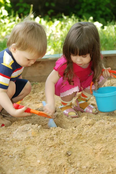 Το αγόρι και το κορίτσι που παίζει σε ένα sandbox — Φωτογραφία Αρχείου