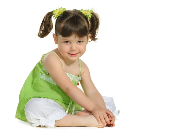 Pretty the little girl sits on the white — Stock Photo, Image