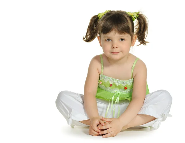 Całkiem mała dziewczynka siedzi na biały — Zdjęcie stockowe