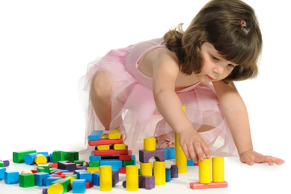 The lovely little girl plays colour wooden cubes — Stock Photo, Image