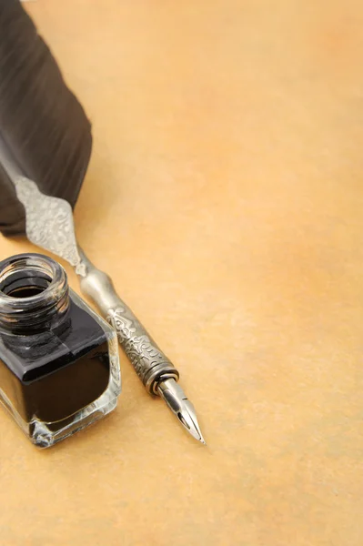 Feather quill and inkwell on an old paper — Stock Photo, Image