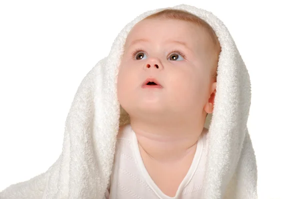 Stock image The baby under a towel. Age of 8 months. It is isolated on a whi