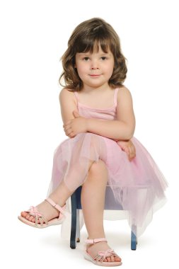 Pretty the little girl sits on a stool clipart