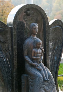 Monument of the woman with the child on a cemetery clipart