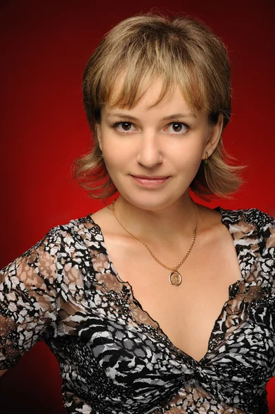 Retrato de la joven sobre un fondo rojo — Foto de Stock