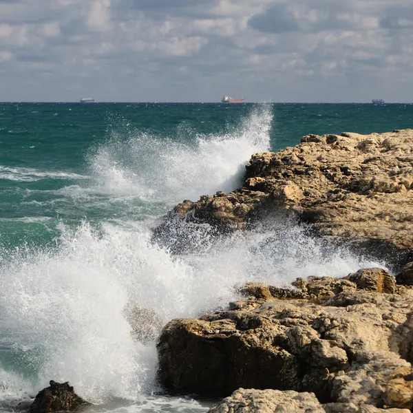Éclaboussure de vagues sur les pierres côtières — Photo