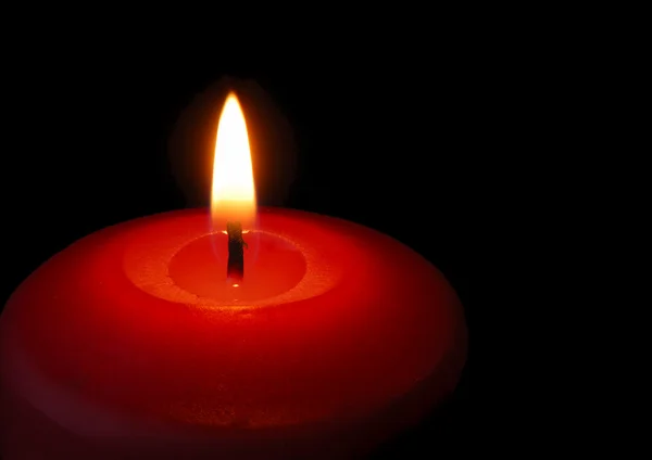 Vela. Una llama ardiente de una vela de color rojo —  Fotos de Stock