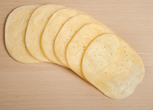 Cutting of cheese on a board on cutting of products — Stock Photo, Image