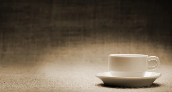 Белая чашка на граненом фоне — стоковое фото