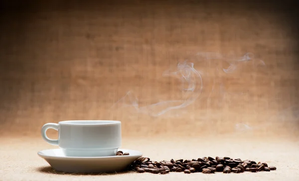 Чашка гарячої кави про пором і зерна кави на гранж — стокове фото